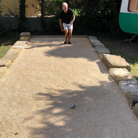 Personne jouant à la pétanque sur le terrain dédié des Volets Bleus Provence
